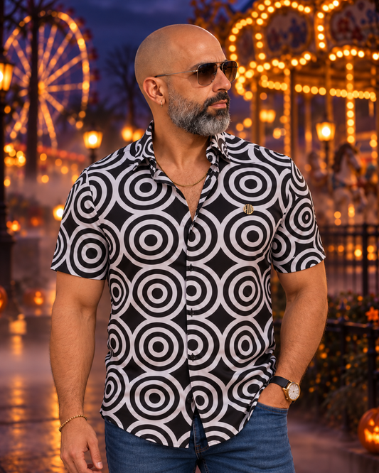 Edberto con gafas y camisa MW Hypnotic negra y blanca de círculos concéntricos en un ambiente nocturno